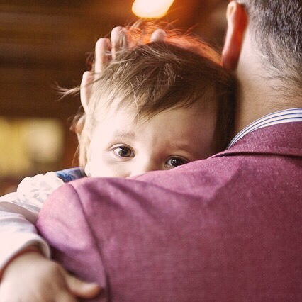 Un niño en brazos de su padre.